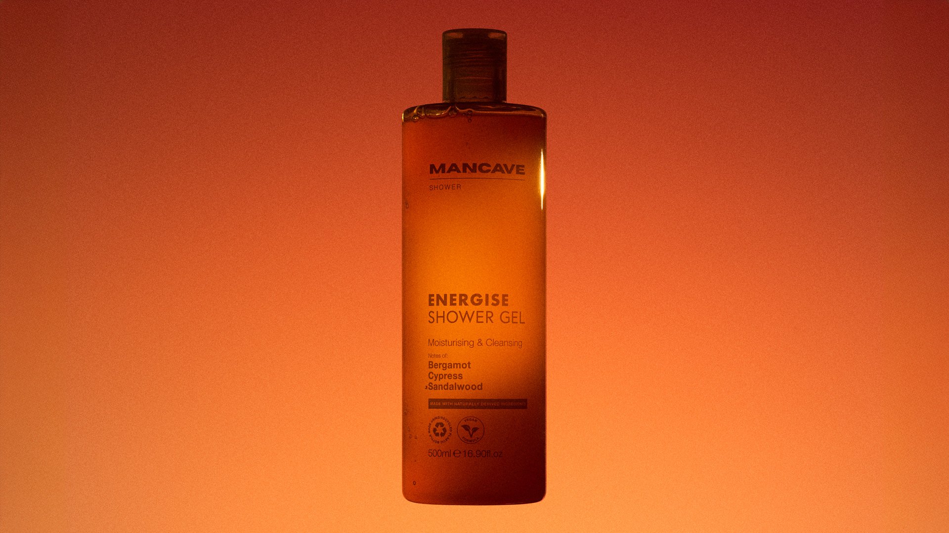 Mancave Energise shower gel 500ml bottle placed on an orange gradient backdrop
