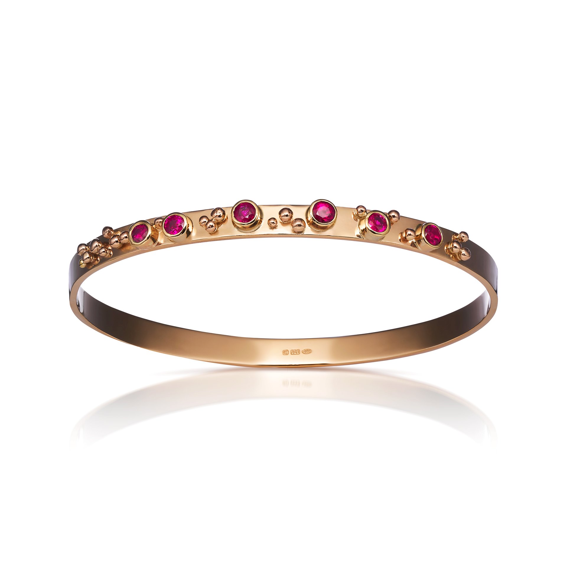 Gold bangle bracelet decorated with pink gemstones and small gold beads.