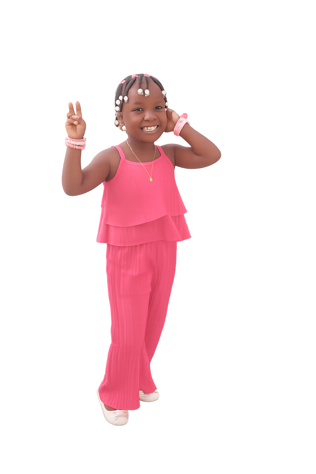 A young girl in a pink sleeveless top and matching pink pants smiling and making a peace sign with her right hand, standing against a dark background.
