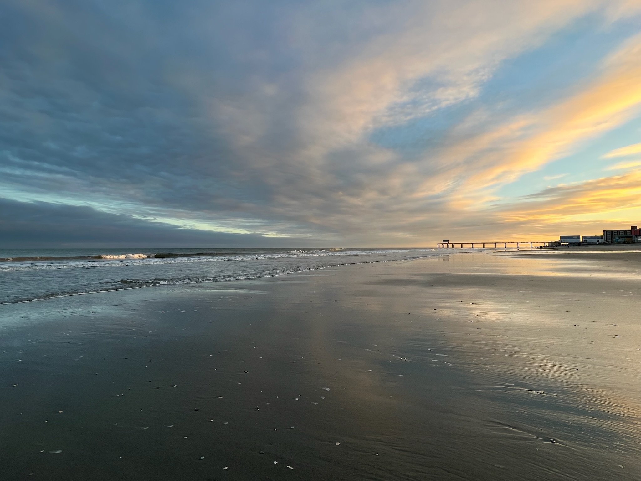 Sunset over the beach and pier, the kind of vacation view that inspires Kathleen Allen's Pinnacle Cruise Line romance novels, including Cruise Crush, Cruise Fling, and Two Tickets to Love