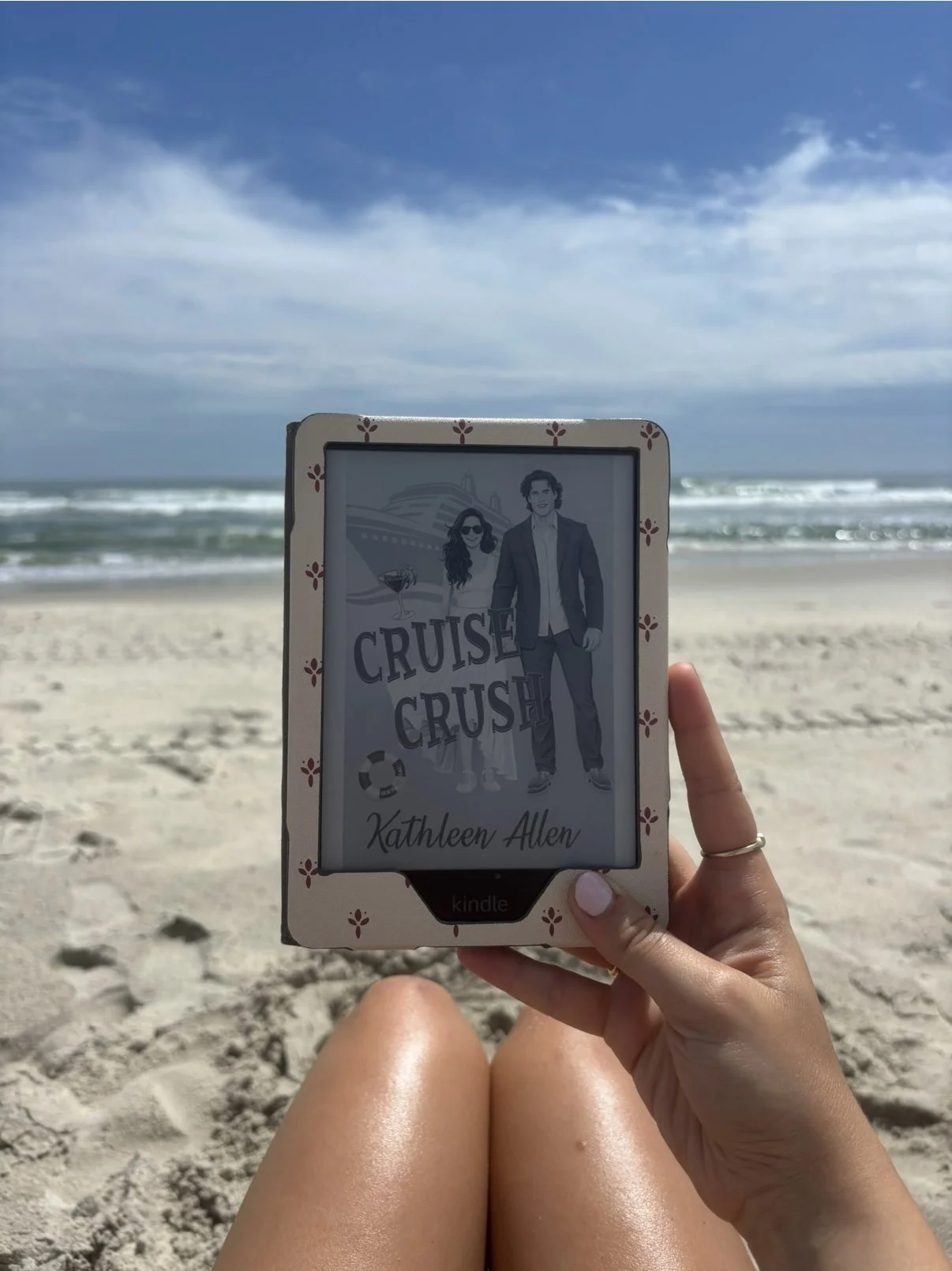 Reading Cruise Crush by Kathleen Allen on a Kindle at the beach, with ocean waves in the background — a cruise ship romance novel from the Pinnacle Cruise Line series, perfect for beach reads and vacation romance.
