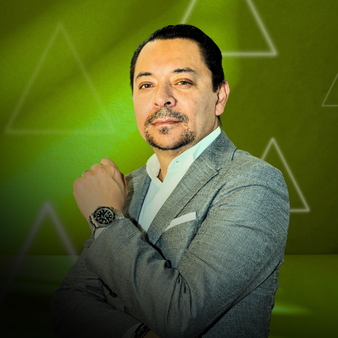 Hombre de negocios con traje gris, frente a fondo verde con formas geométricas, mirando hacia la cámara