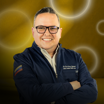 Retrato de un hombre con gafas, sonriendo, con ropa oscura, fondo dorado con círculos luminosos.