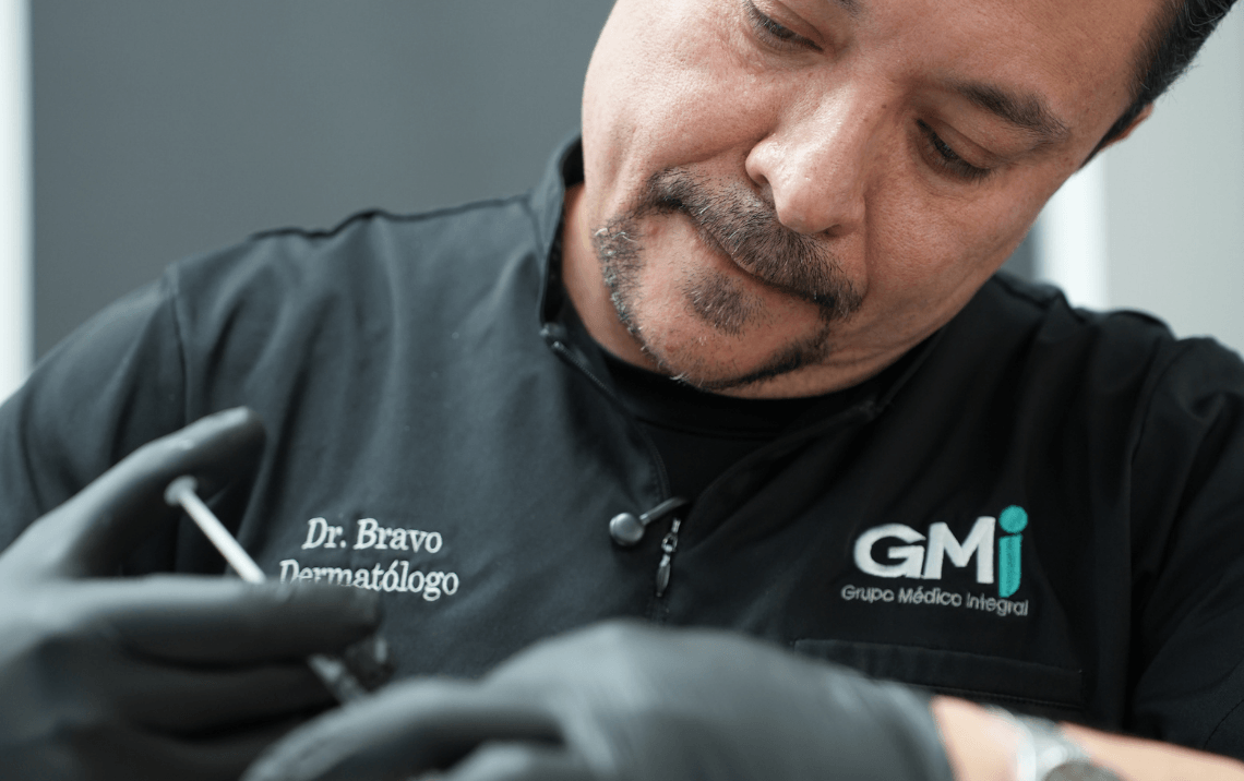 Un dermatólogo de cabello corto y barba, vestido con una chaqueta negra con el nombre 'Dr. Bravo' y la palabra 'Dermatólogo', haciendo un procedimiento médico en una mano, usando guantes grises, en un ambiente clínico.