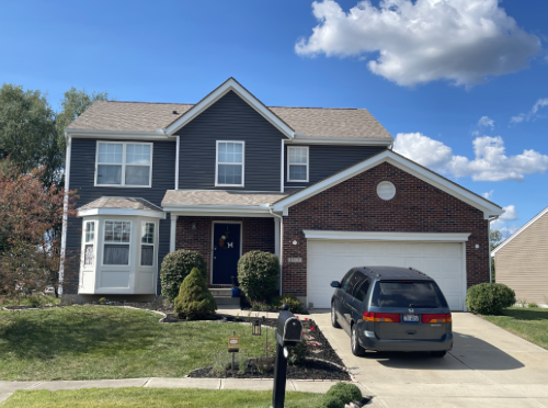 Two-story home with new gray siding and brick accents