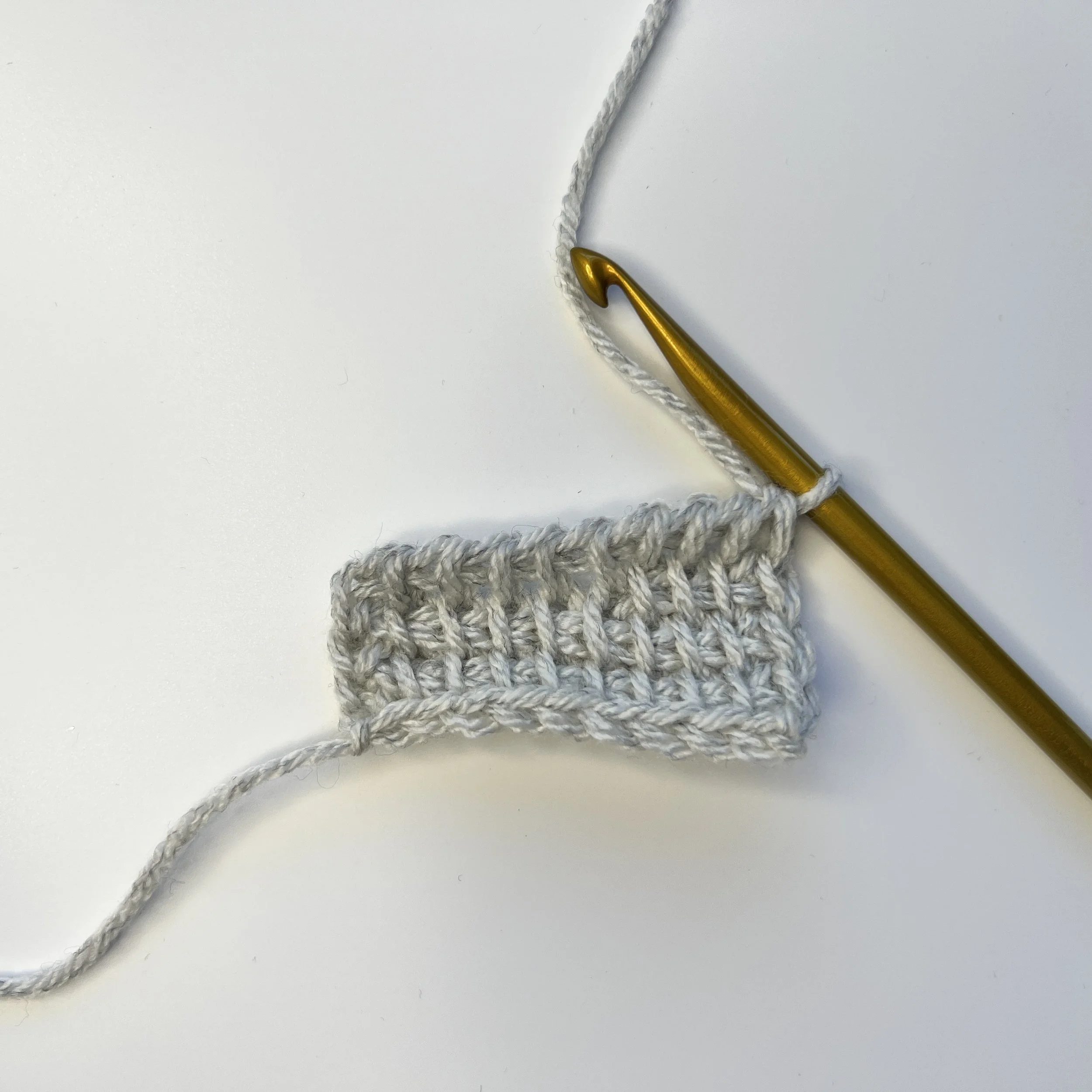 Row above the short row: Tss in each st until the marked st, pick up both the front and back loops of the marked st (the same as you would for an edge st at the end of a row), then continue the row like normal to the end – tss to end, pick up a loop 