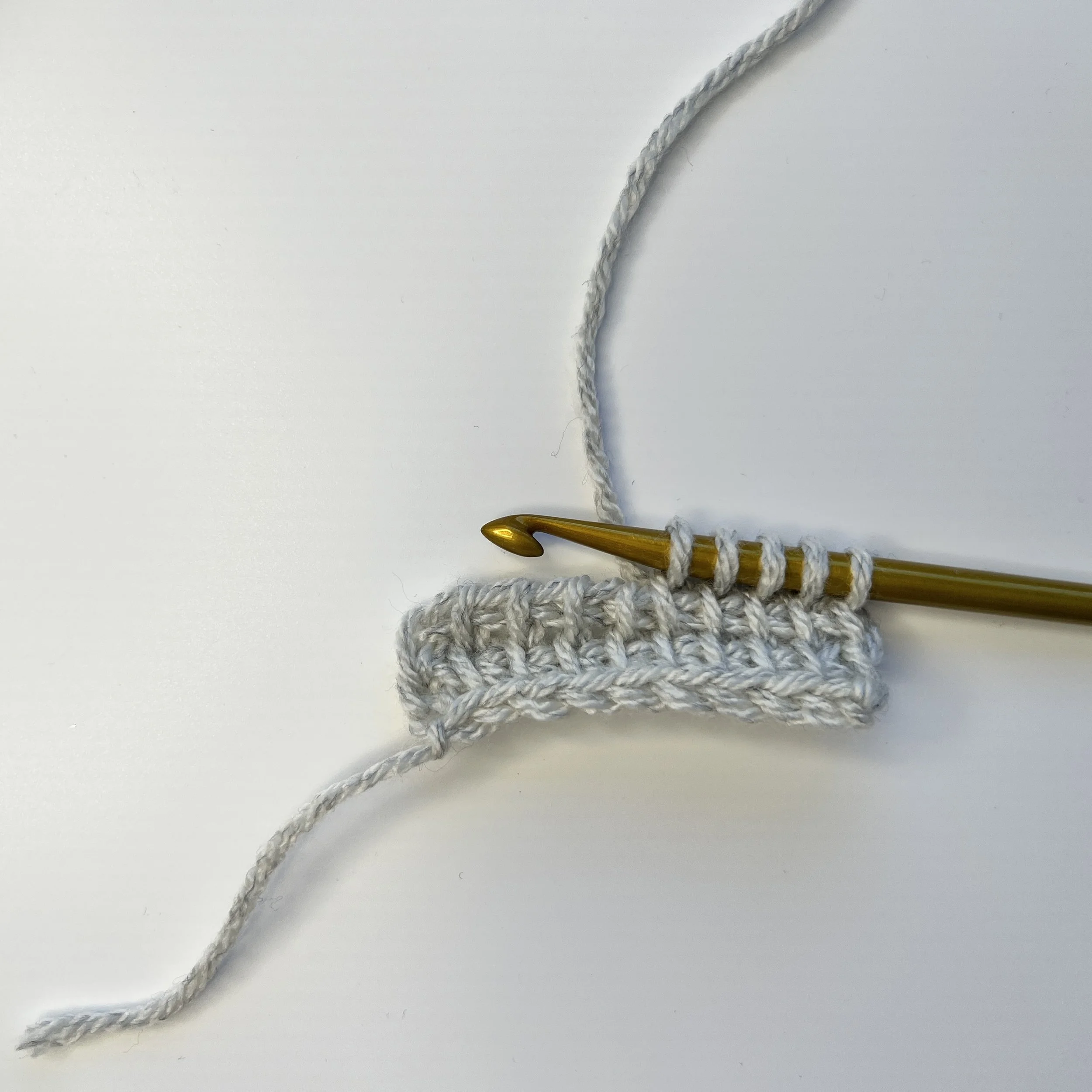 Start with a base of Tunisian simple stitches. My sample has 10 ch and 10 tss x 2 rows. 
Short Row FP: Pick up a number of sts that is less than the full row, eg pick up 4 tss ­– 5 loops on hook.
Optional tip: Place one marker around the front and ba