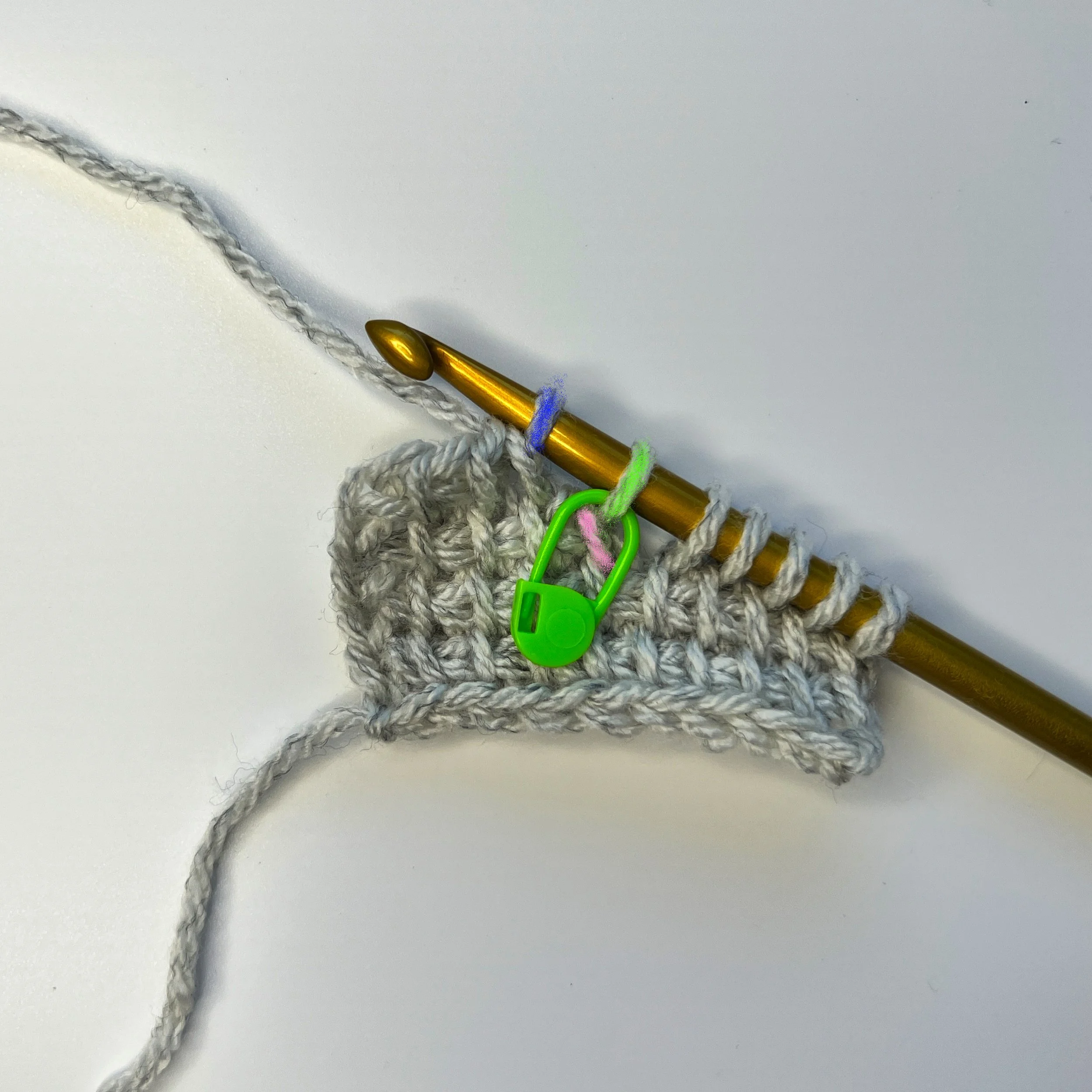 (Remove hook from live loop [blue], insert hook into vertical bar [pink] below the marked st [green], reinsert the hook into the live loop (blue), yarn over, pull through three loops), *yarn over, pull through 2 loops* until 1 loop remains on hook.
T