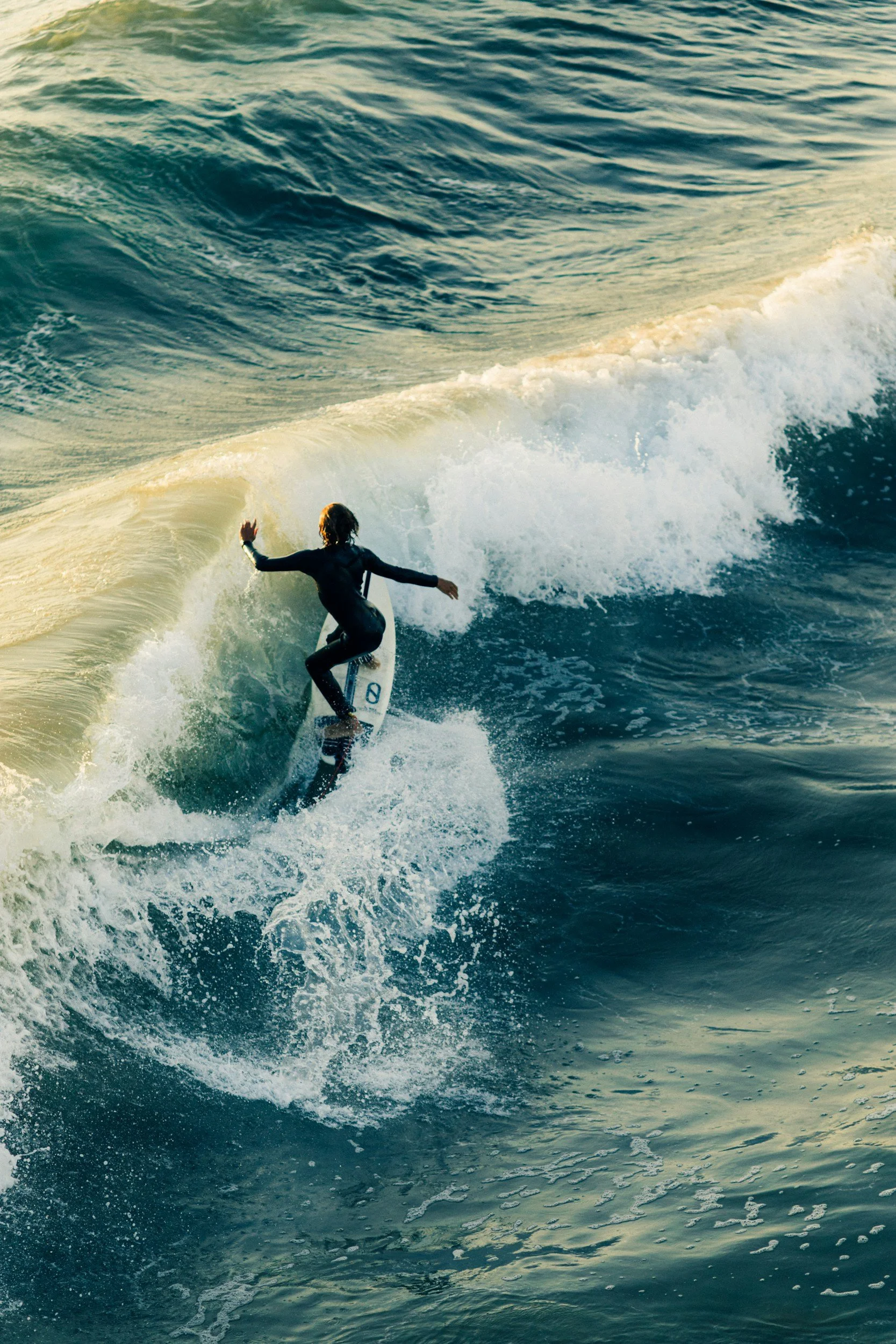 A person surfing on a wave in the ocean during daylight hours.