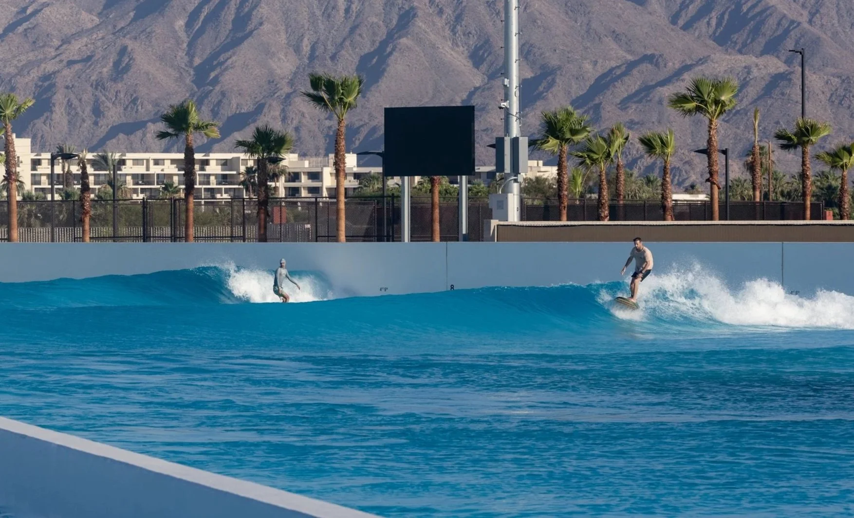 A person surfing on a wave at a surfing area named DSRT Surf with a person in the water nearby.
