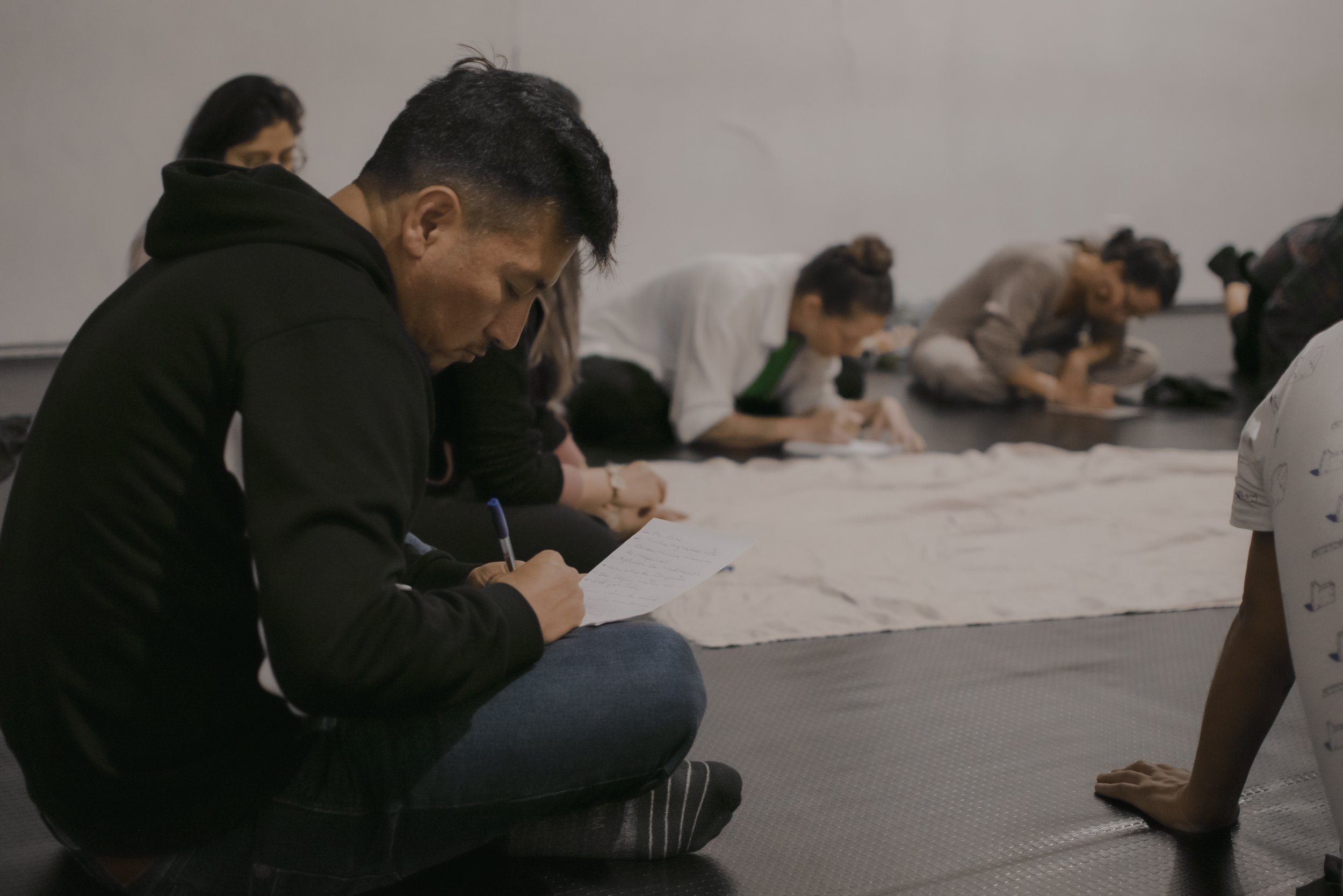 Hombre escribiendo en cuaderno en un entorno tranquilo, práctica de reflexión y claridad personal en un taller de liderazgo y desarrollo personal.