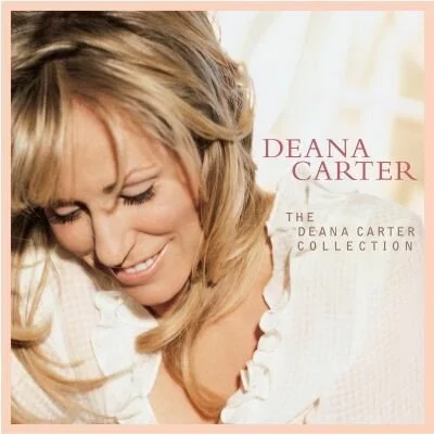 Close-up of a smiling woman with blonde hair looking down on a soft pink background. Text reads 'Deana Carter, The Deana Carter Collection.'