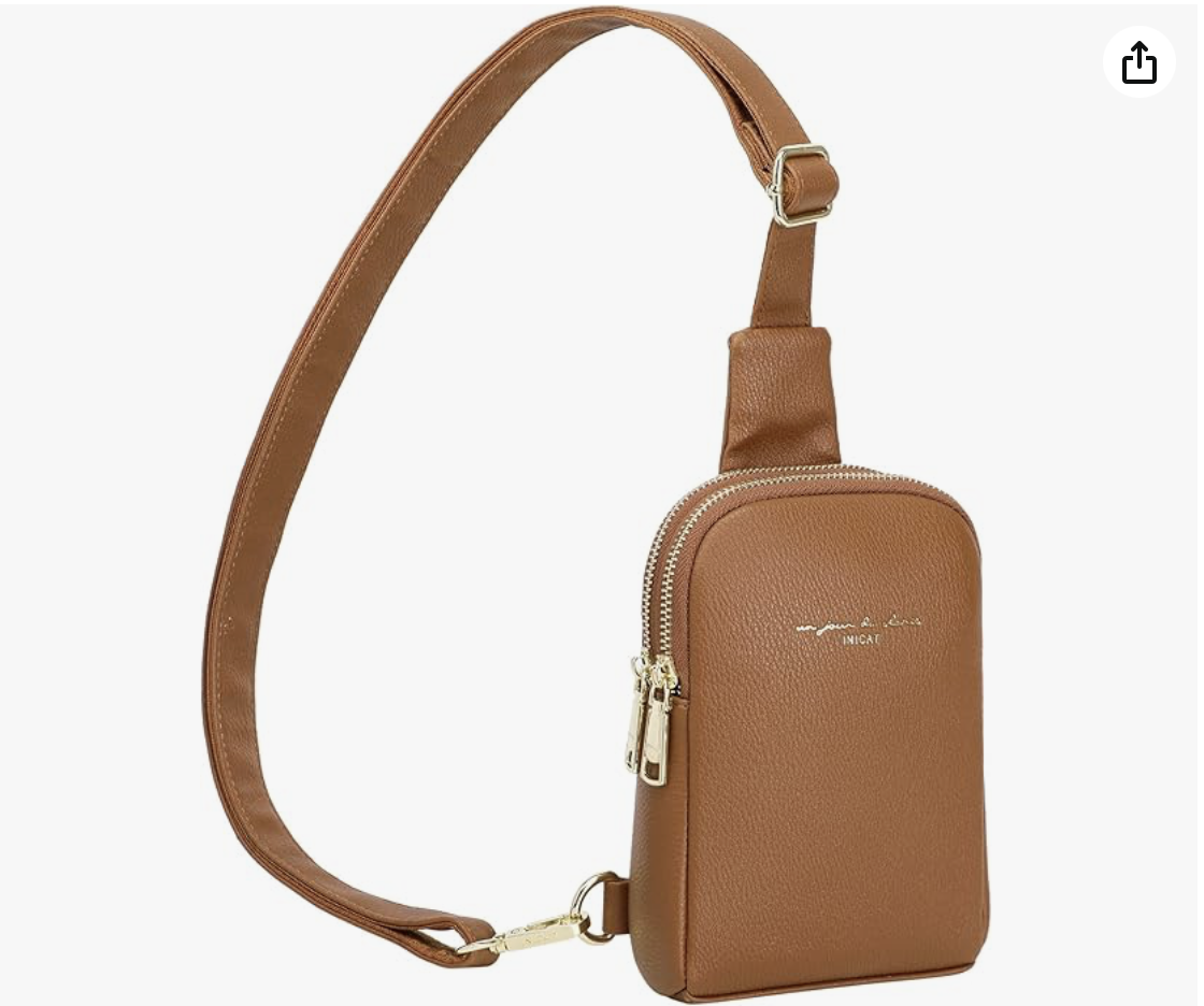 Brown crossbody bag with a front zip pocket and adjustable strap, gold hardware, and printed text on the front.