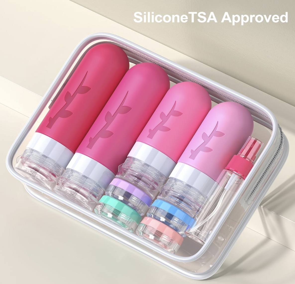 A travel kit containing four pink bottles with a leaf logo, a small spray bottle, and a few small containers, all inside a clear plastic case labeled "SiliconeTSA Approved."