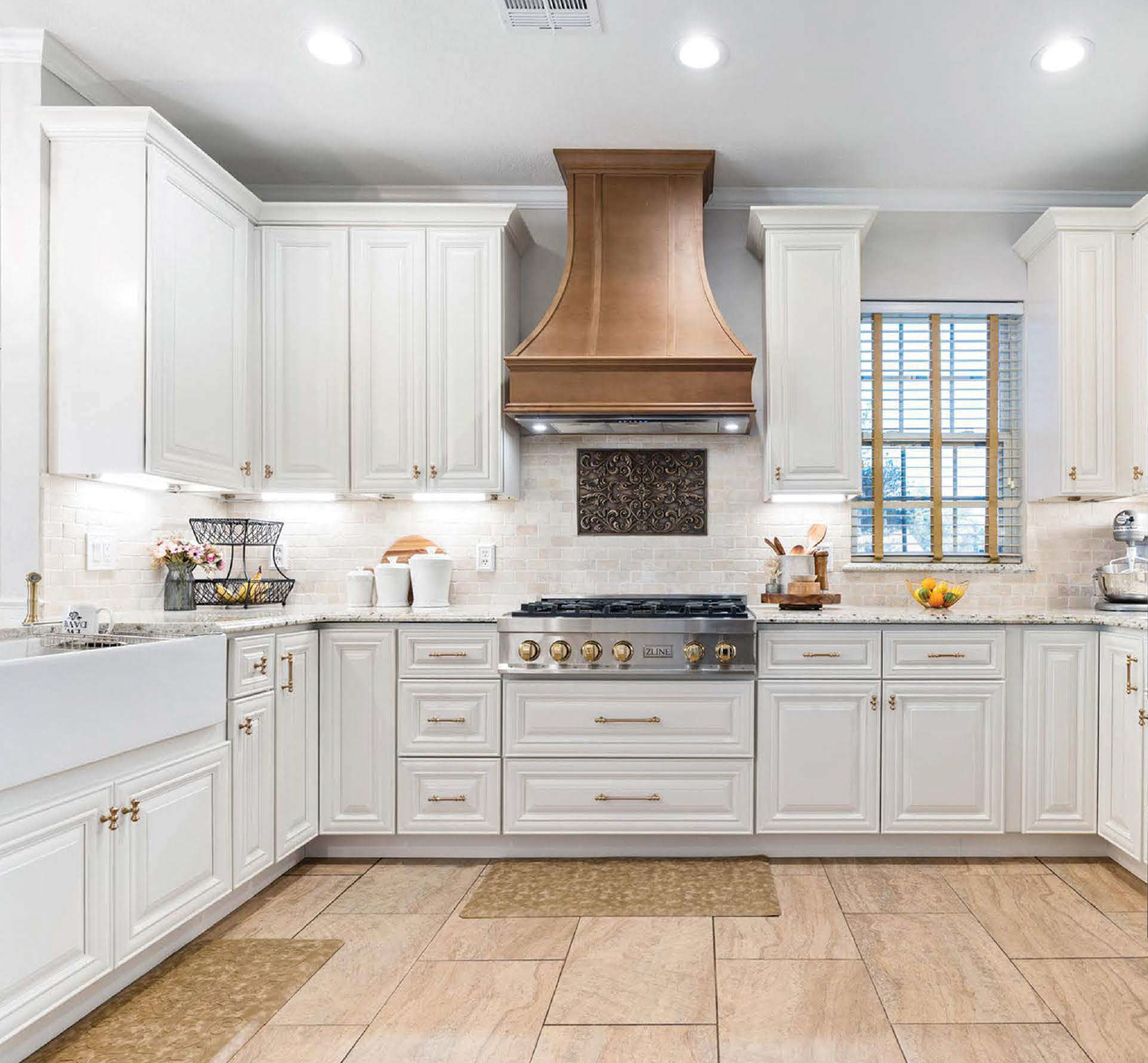 White kitchen with cabinetry, a stove, a copper range hood, window with blinds, and kitchen accessories.