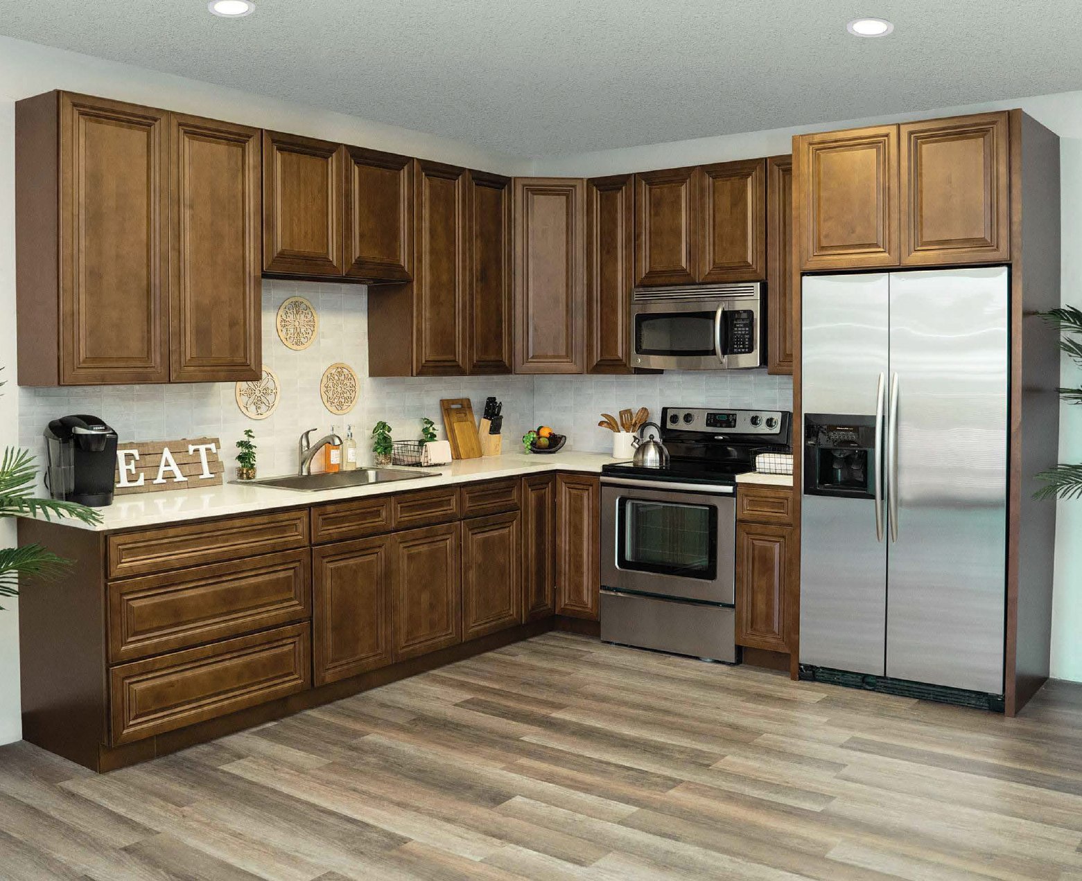 Kitchen with wood cabinets, stainless steel appliances, a white countertop, and decorative wall hangings.