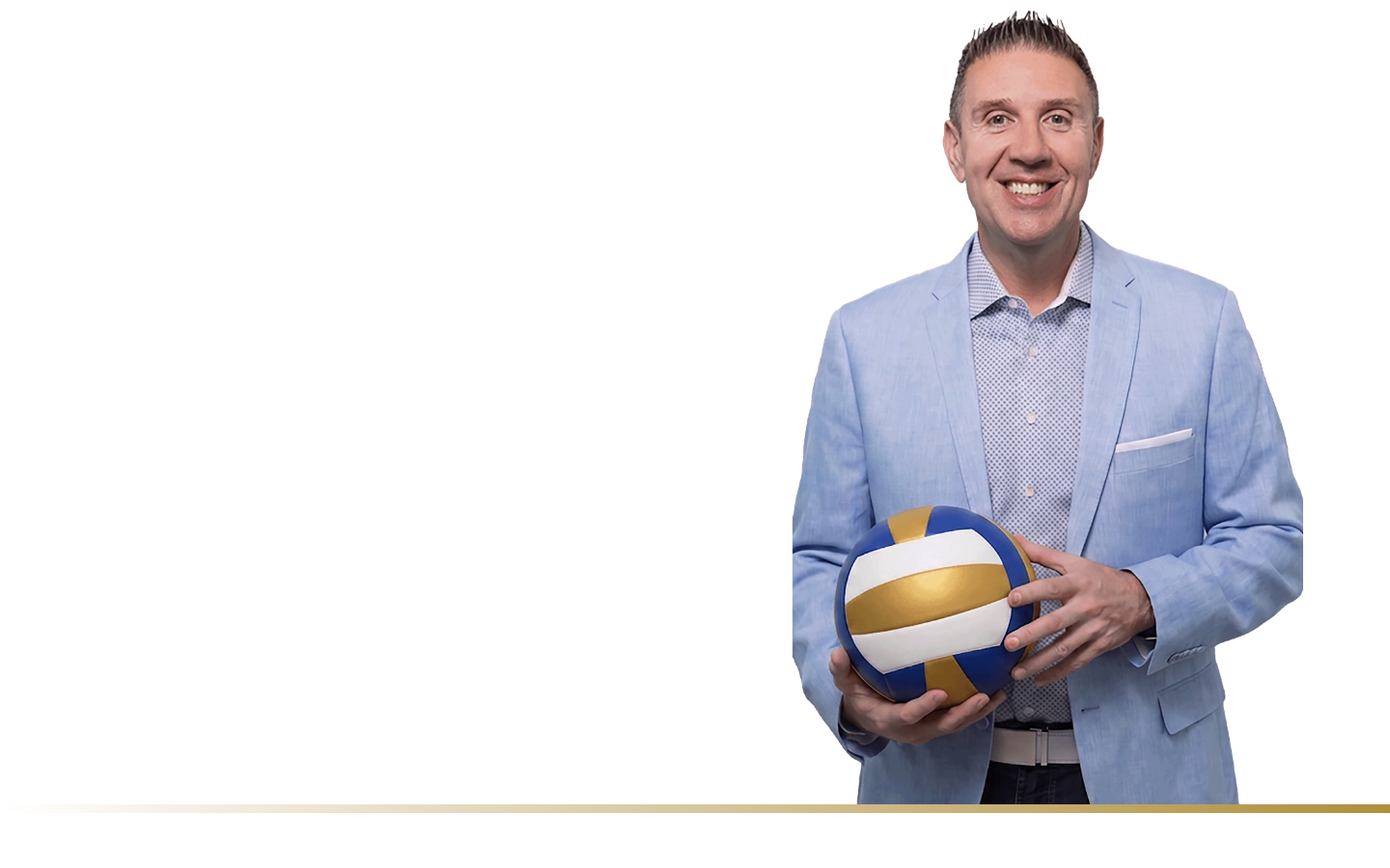A man in a light blue blazer holding a blue and gold volleyball, smiling, standing against a black background.