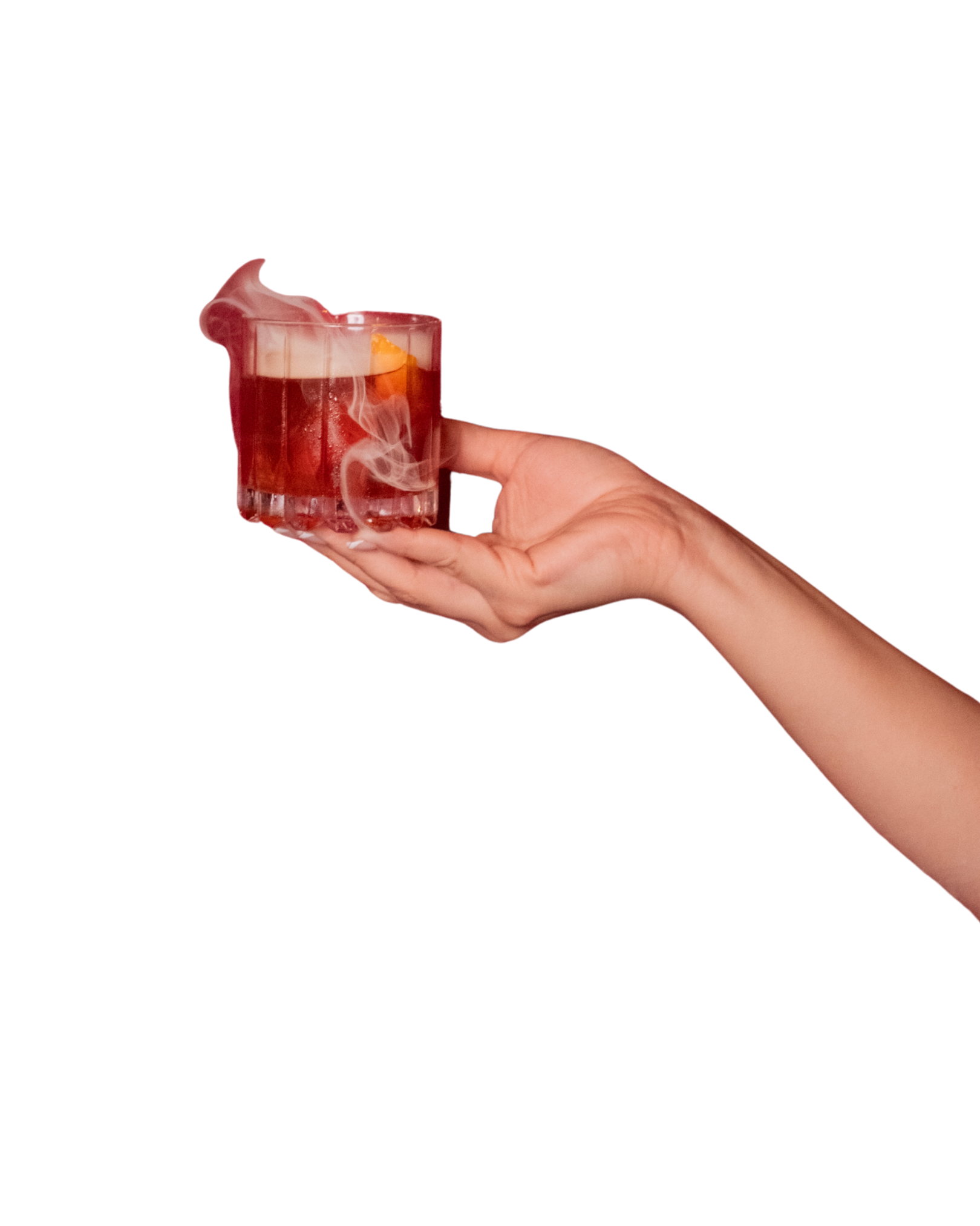 A hand holding a glass of steaming hot tea with a slice of lemon inside.