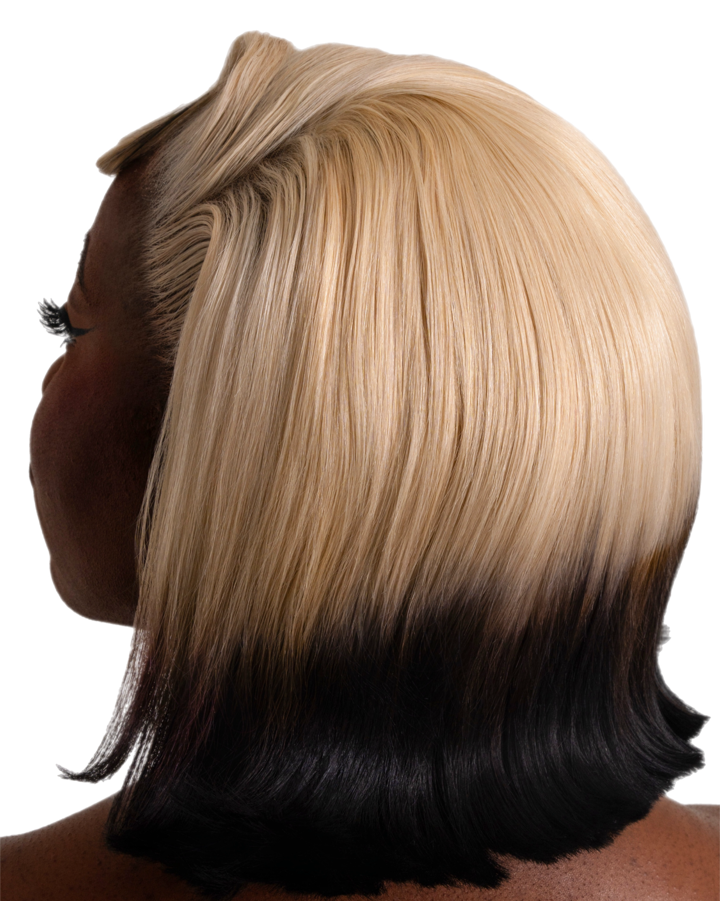 Close-up of a person's hairstyle with blonde hair on top, dark brown hair underneath, and black hair at the tips, viewed from the back.