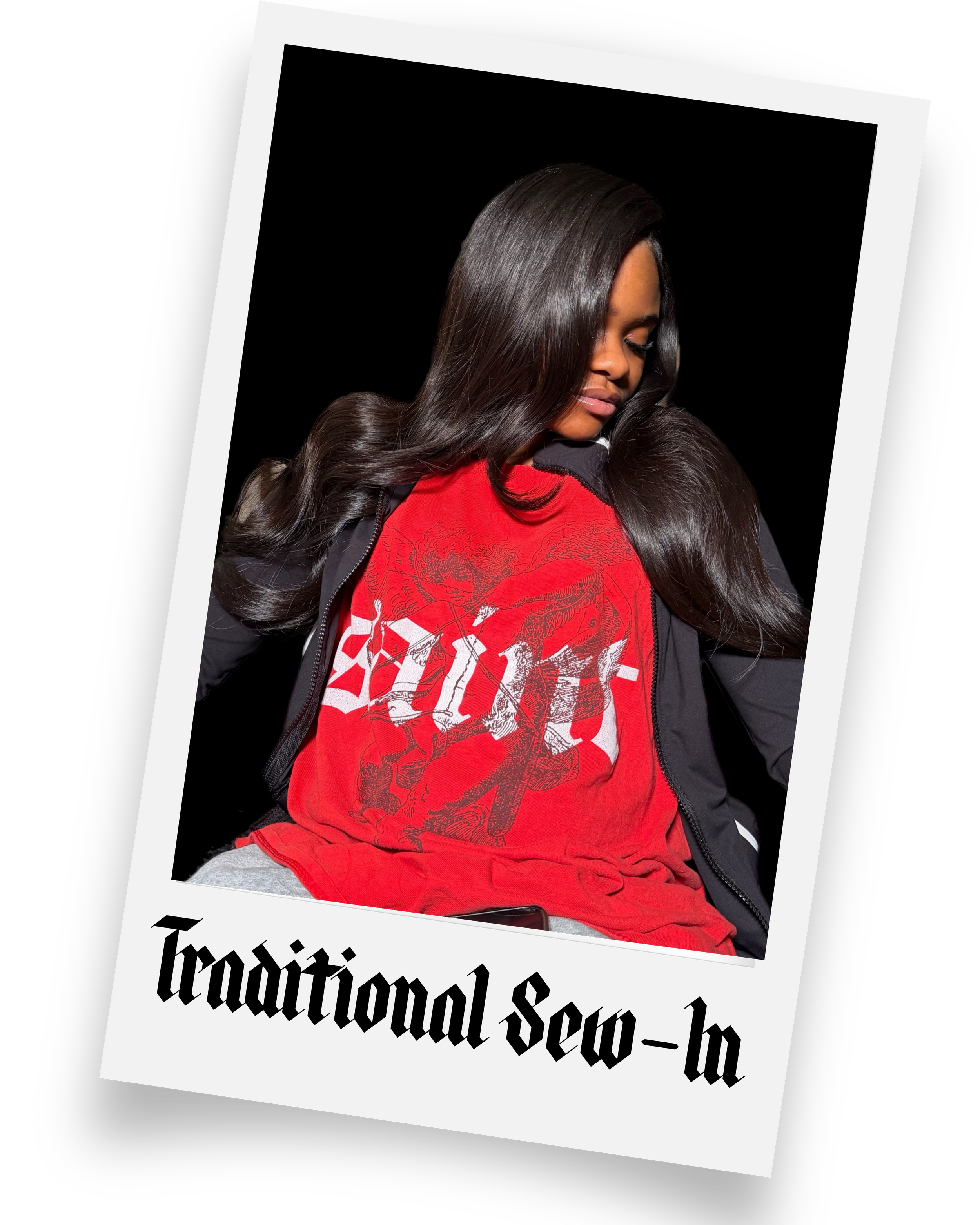 A woman with long dark hair wearing a red graphic T-shirt and a black jacket, sitting against a black background.