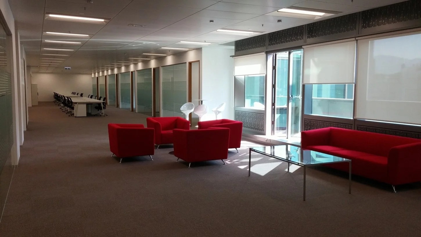 Vibrant breakout lounge with bold red armchairs, designed for informal meetings and team relaxation.
活力十足的休息區，鮮紅色單人沙發設計，適合非正式會議與團隊休憩交流