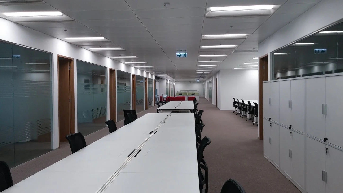 Spacious open-plan workspace featuring long rows of workstations and clean architectural lines for maximum efficiency.
寬敞開放式辦公空間，長形工作站排列搭配簡潔建築線條，最大化空間效率與工作流暢度。