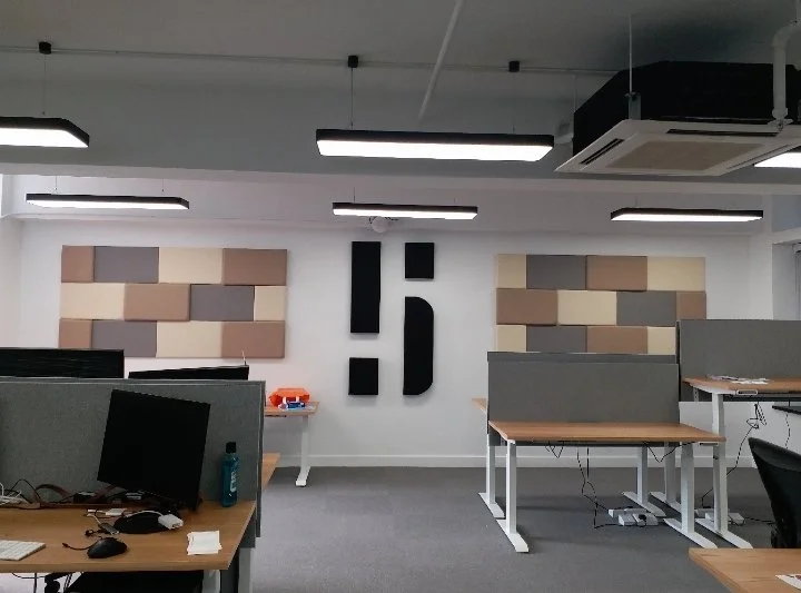 Modern open-plan office with colourful acoustic wall panels and organised workstations for enhanced focus and collaboration.
現代開放式辦公區，彩色吸音牆板搭配整齊工作站，既提升專注力，又促進團隊合作