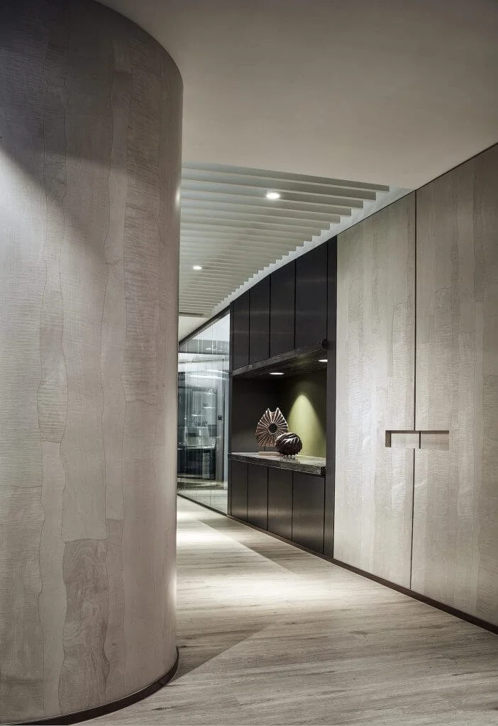 Curved Wooden Corridor — Fintech Headquarters, Central
A sculptural concrete pillar and minimalist corridor create a sophisticated arrival experience with soft lighting and clean architectural lines.

木材圓柱與極簡走廊，配以柔和燈光，打造高端現代的入口體驗