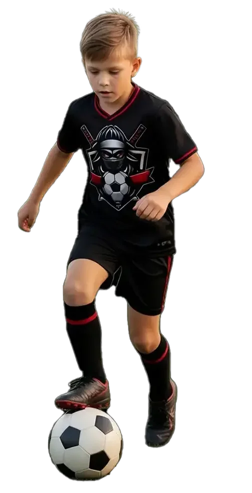 Young boy in black soccer uniform dribbling a soccer ball.