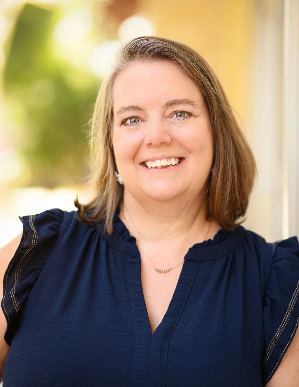 Portrait of Jennifer Tobey, founder and owner of Tobey Financial (Expert Accounting Services in Texas) wearing a navy blue blouse