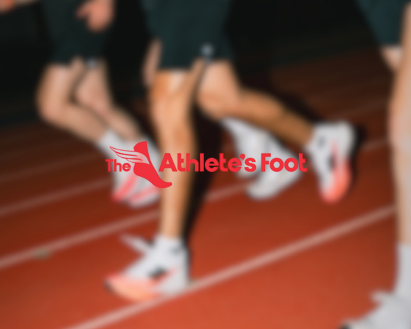 Blurry image of athletes' legs and feet on a running track, with a logo that says 'The Athlete's Foot' in the foreground.