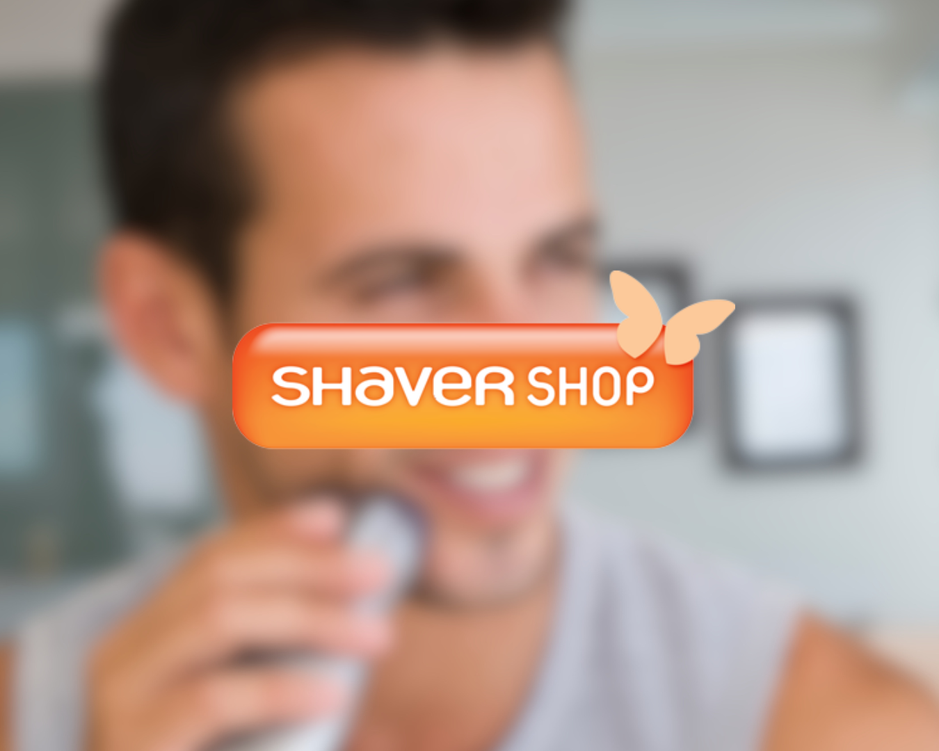 A young man shaving with an electric razor, smiling, with the logo 'Shaver Shop' and butterfly graphic overlaying the image.