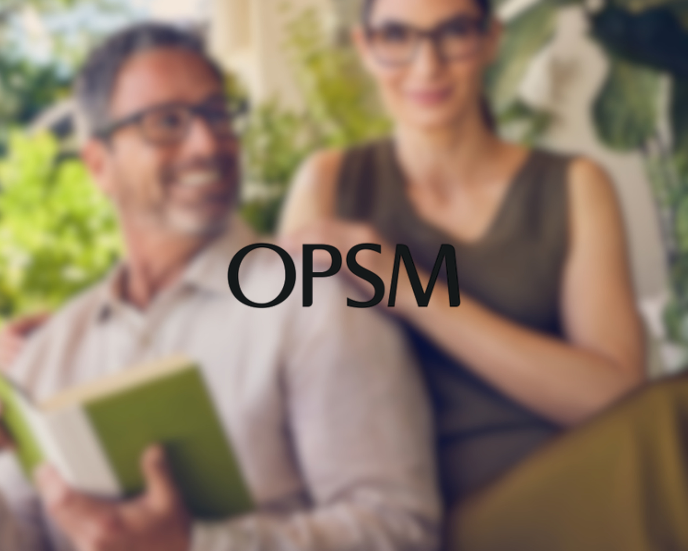 Two people smiling, one holding a green book, with the word 'OPSM' overlaid on the image.