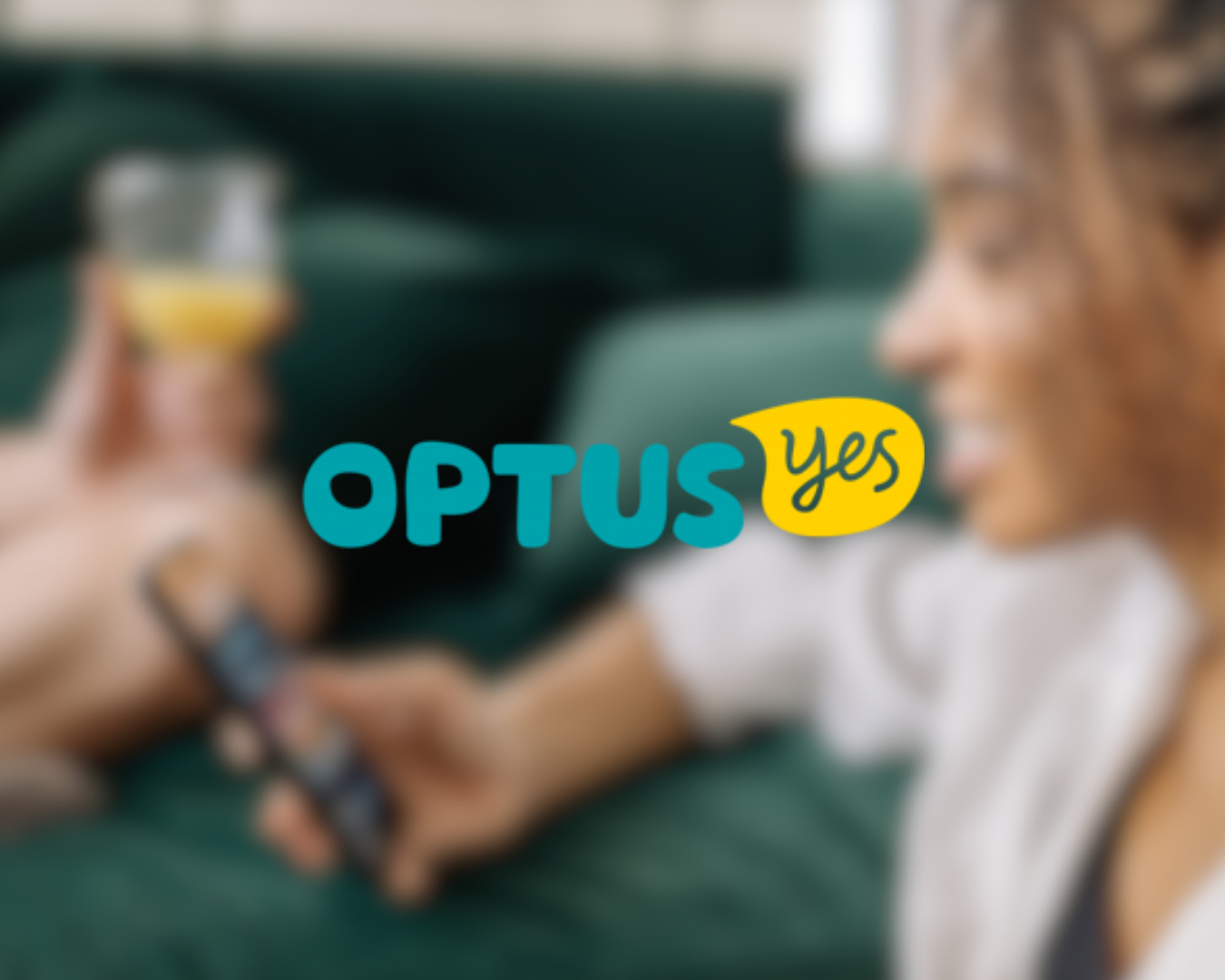 Close-up of a woman holding a glass of orange juice and a person using a remote control with the Optus 'yes' logo overlayed.