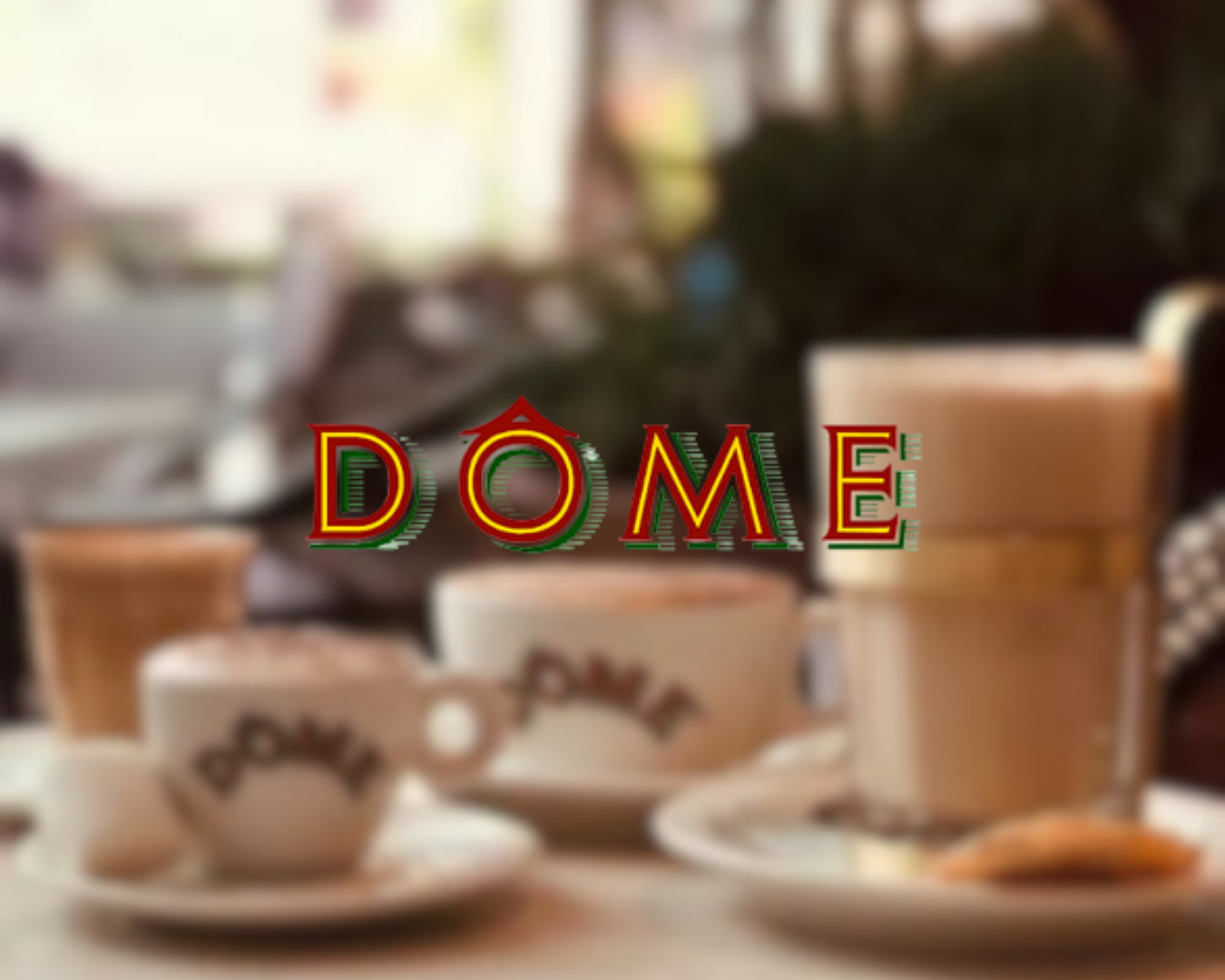 Blurred image of a table setting with cups, saucers, and food, with the word 'DOME' in colorful, outlined letters in the foreground.