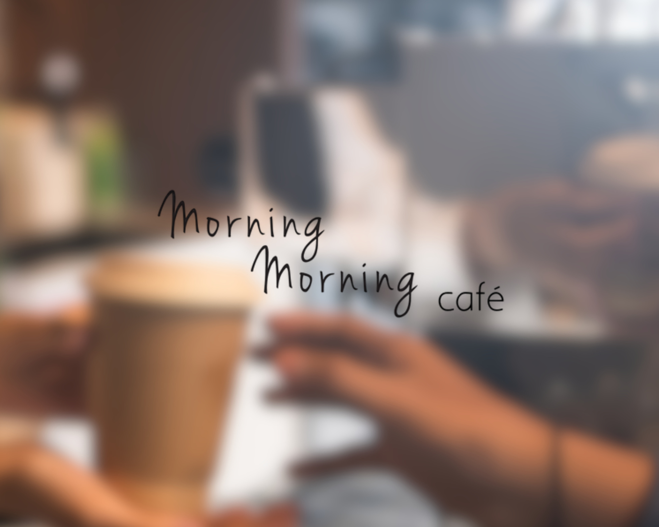 Blurry image of a person using a laptop at a cafe with a coffee cup, with the words 'Morning Morning café' overlaid.