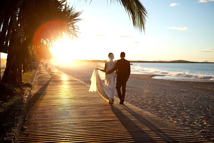 Bride and Groom walking into sunset at Noosa beach