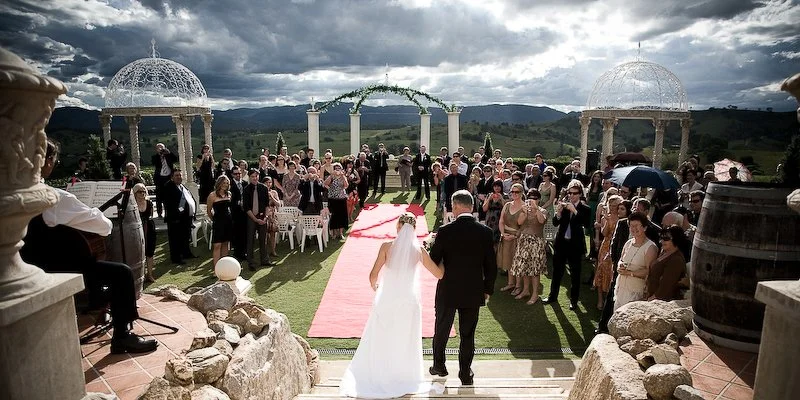 A photographer taking a photo of a bride and groom walking about to be married