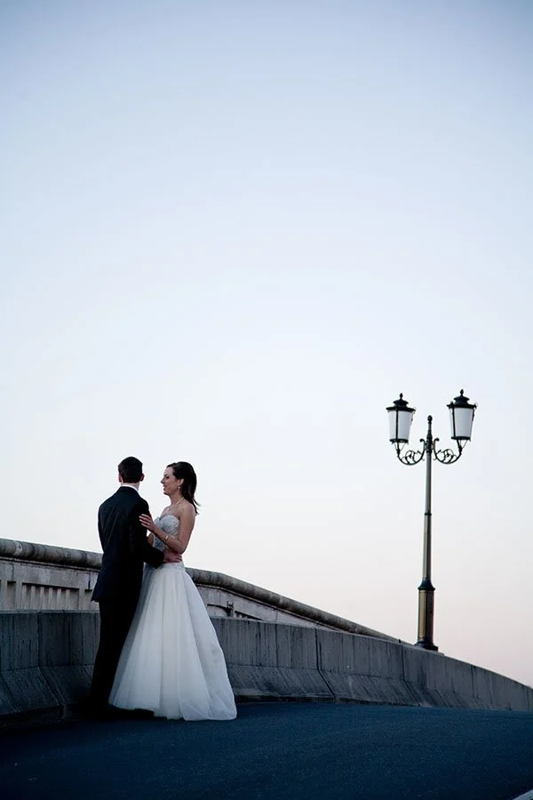 A bride and groom standing close together on a bridge during sunset, Noosa Wedding photography 