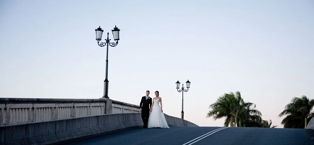 Bride and groom walking on a bridge at sunset at Noosa, Sunshine Coast