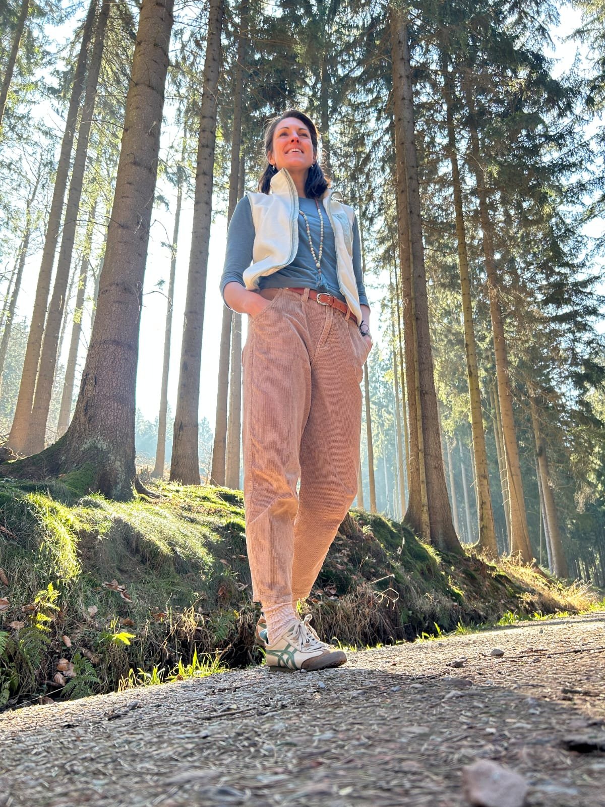 Verena steht stolz und präsent im Wald.