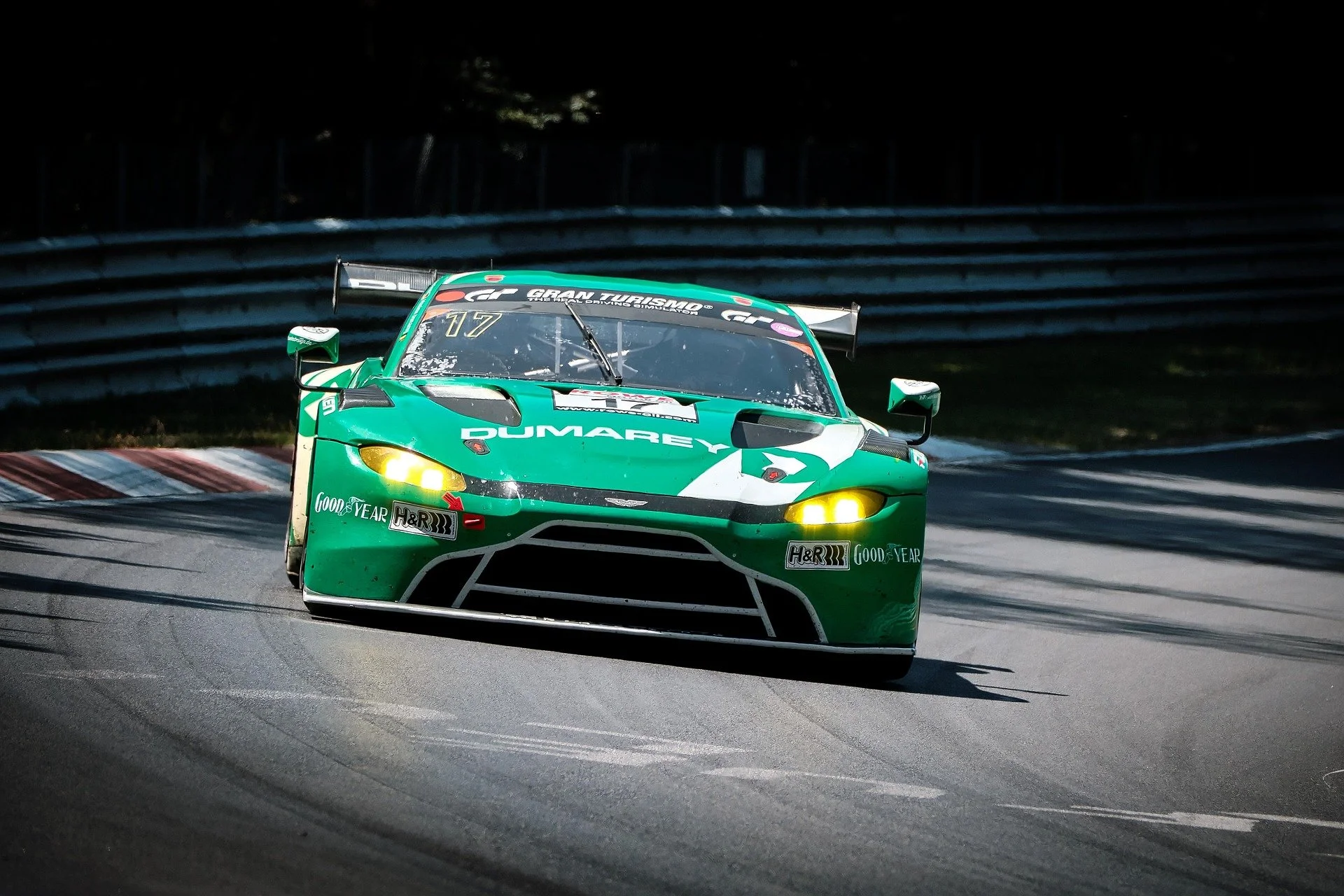 Ein grüner Rennwagen auf einer Rennstrecke in einer Kurve.