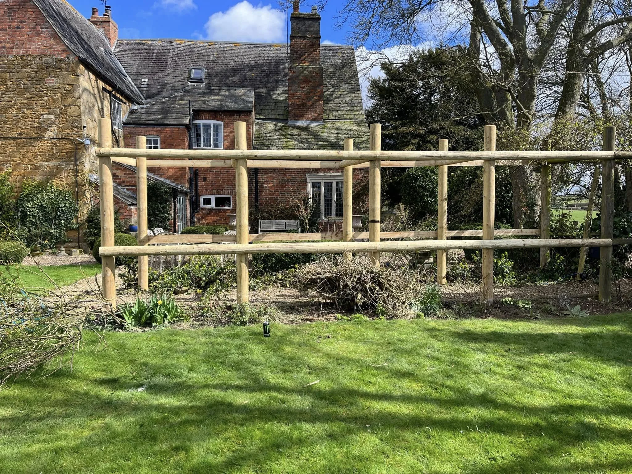 A garden with a new wooden fence in front of home