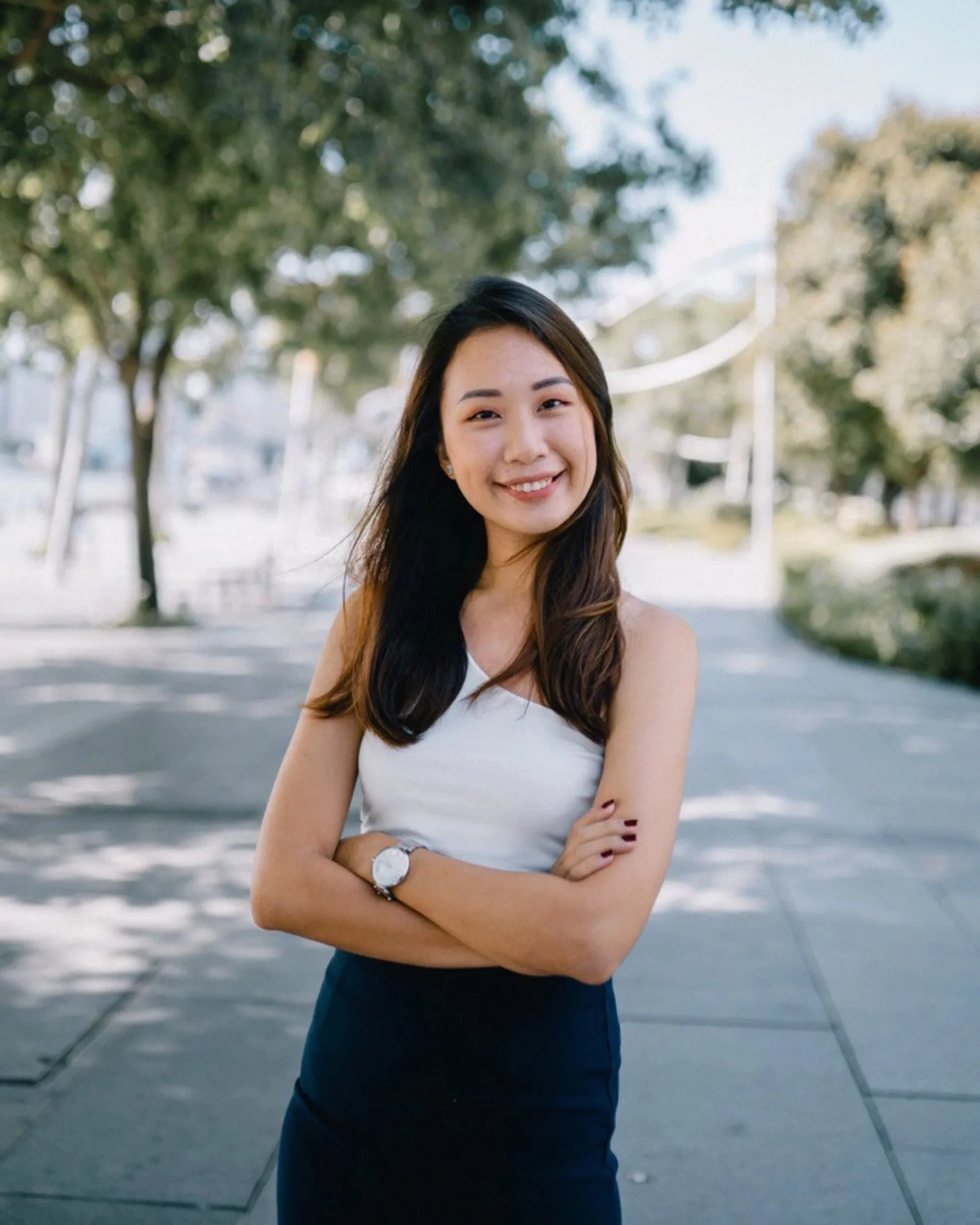 Agatha Neo, Propnex Singapore realtor, top performing from JNA real estate with long dark hair wearing a sleeveless white top and a high-waisted dark skirt.