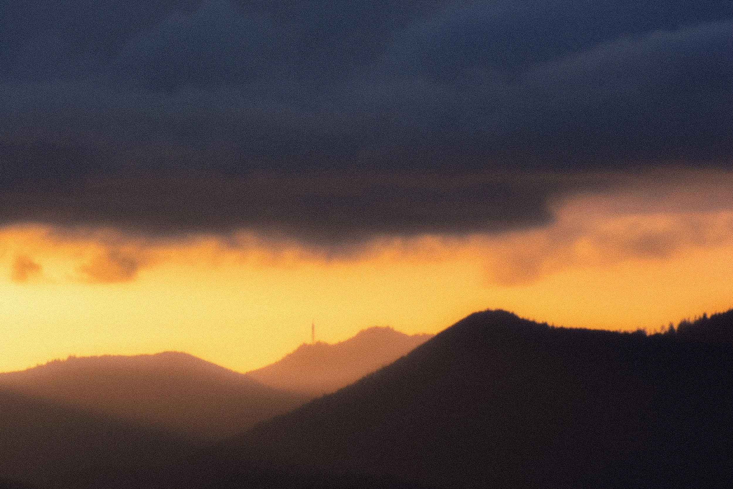 Sunset over mountain range with dark clouds