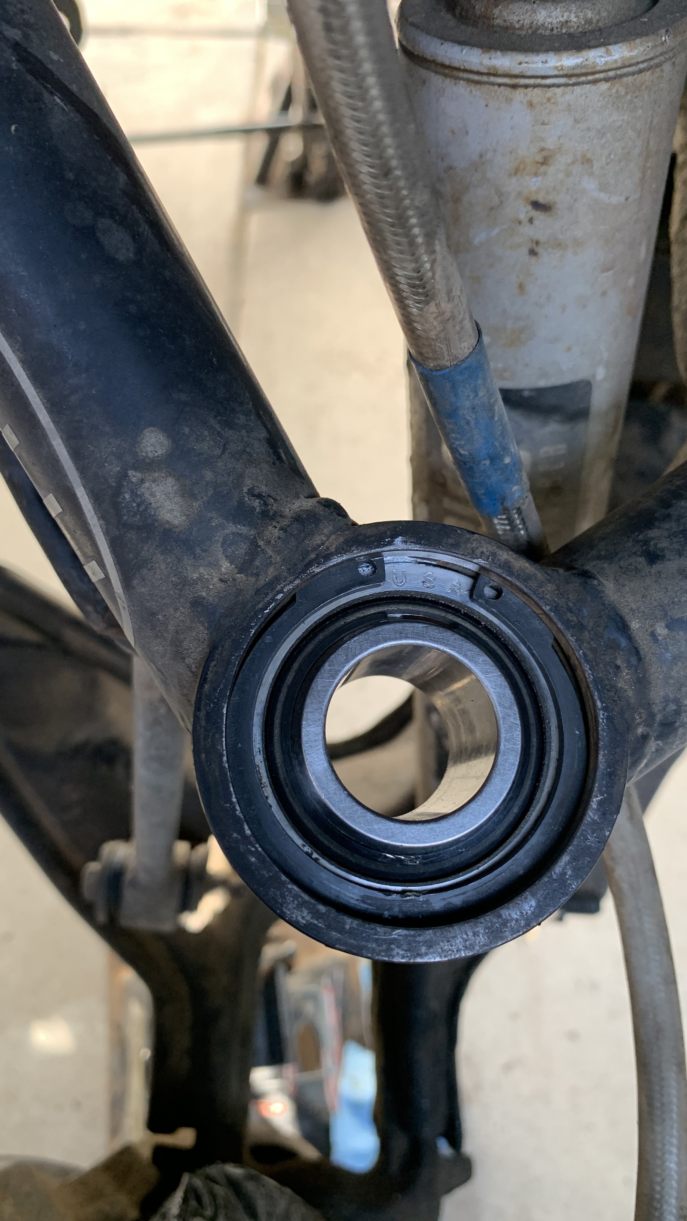 A close-up photo of a upper control arm with new uniball installed.