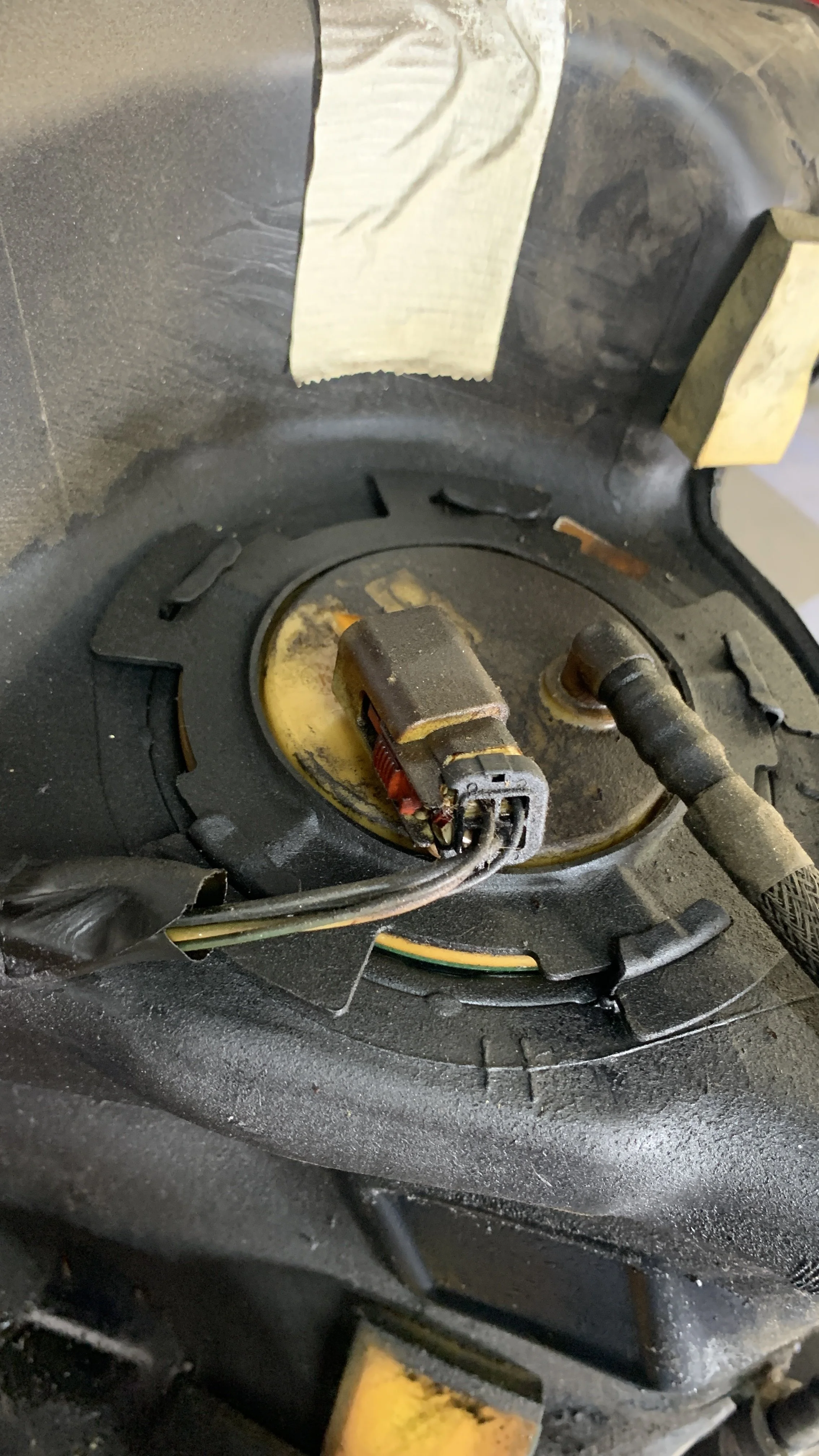 Close-up of a car speaker with disconnected wires and missing speaker grille.