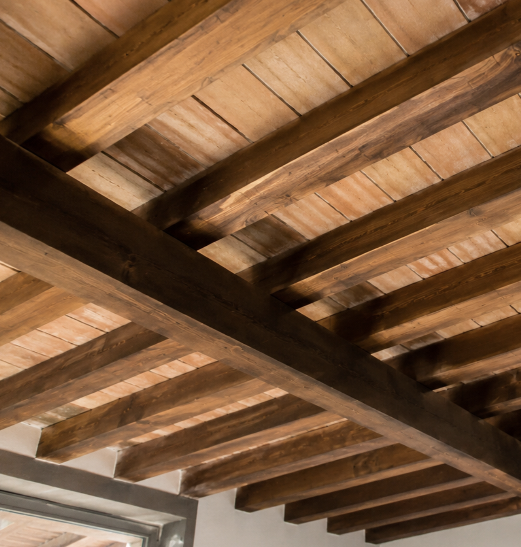 Techo de madera con vigas y techo de ladrillo visto en interiores.