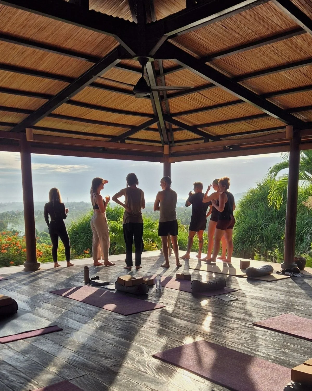 Guests gathering in an open-air yoga shala at sunset during the I Am That Studio Bali retreat