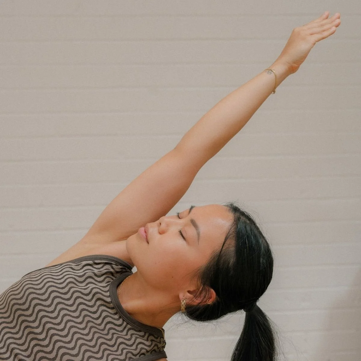 Student practising a side stretch in a Yin Yoga class at I Am That Studio in Collingwood, Melbourne.